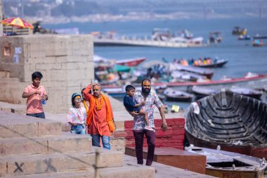 Varanasi, Uttar Pradesh, Hindistan - 05 Mart 2023: Varanasi 'deki çetelerin yakınındaki ghatlarda geleneksel giysiler giyen insanlar.