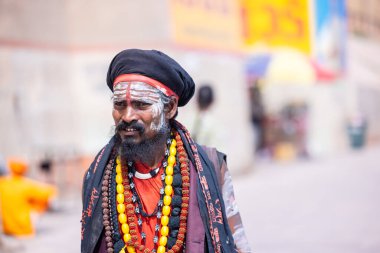 Varanasi, Uttar Pradesh, Hindistan - 05 Mart 2023: Varanasi 'deki çetelerin yakınındaki ghatlarda yürüyen geleneksel sadhu baba resmi. Kashi en eski ve kutsal şehirdir.