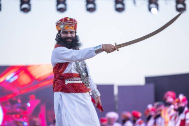 Bikaner, Rajasthan, Hindistan - 14 Ocak 2023: Bikaner deve festivalinde geleneksel Rajasthani elbisesi, mücevheri ve türban giyen sakallı ve bıyıklı bir rajasthani erkeğinin portresi.