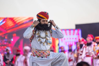 Bikaner, Rajasthan, Hindistan - 14 Ocak 2023: Bikaner deve festivalinde geleneksel Rajasthani elbisesi, mücevheri ve türban giyen sakallı ve bıyıklı bir rajasthani erkeğinin portresi.