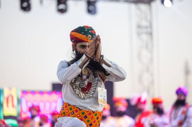 Bikaner, Rajasthan, Hindistan - 14 Ocak 2023: Bikaner deve festivalinde geleneksel Rajasthani elbisesi, mücevheri ve türban giyen sakallı ve bıyıklı bir rajasthani erkeğinin portresi.