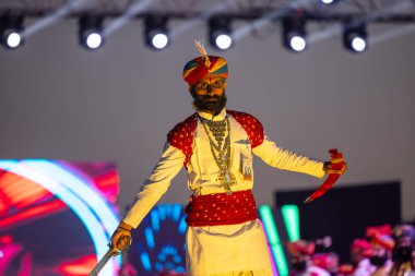 Bikaner, Rajasthan, Hindistan - 14 Ocak 2023: Bikaner deve festivalinde geleneksel Rajasthani elbisesi, mücevheri ve türban giyen sakallı ve bıyıklı bir rajasthani erkeğinin portresi.