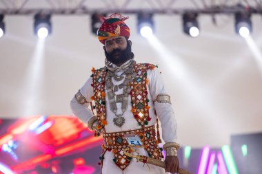 Bikaner, Rajasthan, Hindistan - 14 Ocak 2023: Bikaner deve festivalinde geleneksel Rajasthani elbisesi, mücevheri ve türban giyen sakallı ve bıyıklı bir rajasthani erkeğinin portresi.