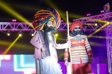 Bikaner, Rajasthan, Hindistan - 14 Ocak 2023: Bikaner deve festivalinde geleneksel Rajasthani elbisesi, mücevheri ve türban giyen sakallı ve bıyıklı bir rajasthani erkeğinin portresi.