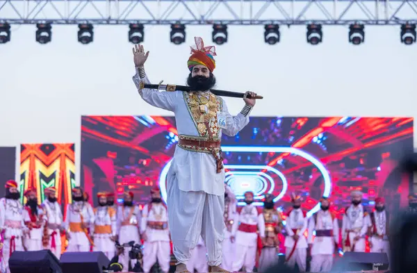 Bikaner, Rajasthan, Hindistan - 14 Ocak 2023: Bikaner deve festivalinde geleneksel Rajasthani elbisesi, mücevheri ve türban giyen sakallı ve bıyıklı bir rajasthani erkeğinin portresi.