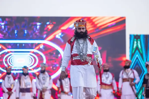 Bikaner, Rajasthan, Hindistan - 14 Ocak 2023: Bikaner deve festivalinde geleneksel Rajasthani elbisesi, mücevheri ve türban giyen sakallı ve bıyıklı bir rajasthani erkeğinin portresi.