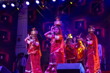 Puşkar, Rajasthan, Hindistan - 05 Kasım 2022: Pushkar Fuarı 'nda geleneksel renkli elbiseler ve ateşli metal kaplarla rajasthani halk dansı yapan kadın sanatçılar. Seçici odak.
