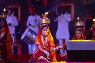 Puşkar, Rajasthan, Hindistan - 05 Kasım 2022: Pushkar Fuarı 'nda geleneksel renkli elbiseler ve ateşli metal kaplarla rajasthani halk dansı yapan kadın sanatçılar. Seçici odak.