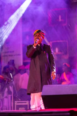 Puşkar, Rajasthan, Hindistan - Kasım 06 2022: Rajasthan 'lı erkek folk sanatçısının portresi geleneksel elbise ve renkli türbanlı deve fuarı sırasında sahneye çıktı