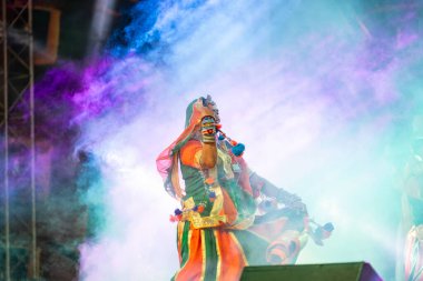 Puşkar, Rajasthan, Hindistan - Kasım 05 2022: Renkli etnik Rajasthani elbisesi içindeki itme kar fuarı sırasında genç ve güzel kadın sanatçının başıyla halk dansını sergileyen portresi.