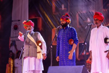 Puşkar, Rajasthan, Hindistan - Kasım 06 2022: Rajasthan 'lı erkek folk sanatçılarının portresi geleneksel elbise ve renkli türbanlı deve fuarı sırasında sahneye çıktı