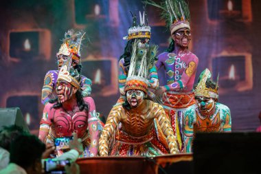 Puşkar, Rajasthan, Hindistan - Kasım 06 2022: Rajasthani halk dansları yapan erkek sanatçılar Sahariya kabilesi boyalı yüzlü ve rengarenk boyalı vücutlu, açık renk elbiseli.