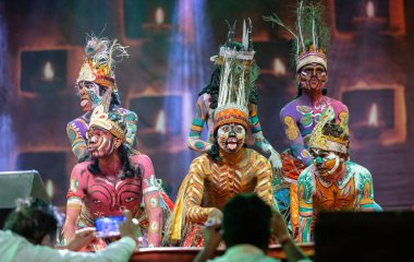 Puşkar, Rajasthan, Hindistan - Kasım 06 2022: Rajasthani halk dansları yapan erkek sanatçılar Sahariya kabilesi boyalı yüzlü ve rengarenk boyalı vücutlu, açık renk elbiseli.