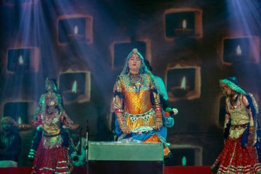 Puşkar, Rajasthan, Hindistan - Kasım 06 2022: Rajasthani halk dansını renkli etnik rajasthani elbise ve mücevherleriyle yapan kadın sanatçı.