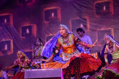 Puşkar, Rajasthan, Hindistan - Kasım 06 2022: Rajasthani halk dansını renkli etnik rajasthani elbise ve mücevherleriyle yapan kadın sanatçı.