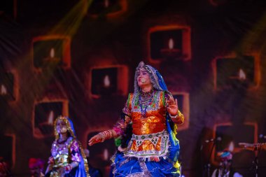 Puşkar, Rajasthan, Hindistan - Kasım 06 2022: Rajasthani halk dansını renkli etnik rajasthani elbise ve mücevherleriyle yapan kadın sanatçı.