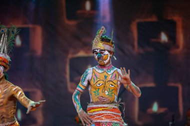 Puşkar, Rajasthan, Hindistan - Kasım 06 2022: Hintli erkek sanatçı rajasthani folk dansı yapıyor Sahariya kabilesi boyalı yüzlü ve renkli boyalı vücutlu, açık renk elbiseli.