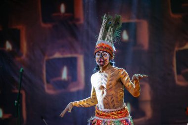 Puşkar, Rajasthan, Hindistan - Kasım 06 2022: Hintli erkek sanatçı rajasthani folk dansı yapıyor Sahariya kabilesi boyalı yüzlü ve renkli boyalı vücutlu, açık renk elbiseli.