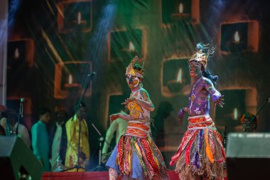 Puşkar, Rajasthan, Hindistan - Kasım 06 2022: Rajasthani halk dansları yapan erkek sanatçılar Sahariya kabilesi boyalı yüzlü ve rengarenk boyalı vücutlu, açık renk elbiseli.