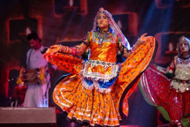 Puşkar, Rajasthan, Hindistan - Kasım 06 2022: Ramazan halk dansını renkli etnik rajasthani elbisesi ve mücevherleriyle sahnede yapan sanatçı.