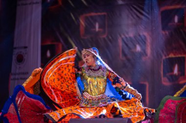 Puşkar, Rajasthan, Hindistan - Kasım 06 2022: Ramazan halk dansını renkli etnik rajasthani elbisesi ve mücevherleriyle sahnede yapan sanatçı.