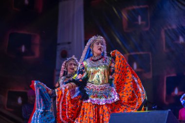 Puşkar, Rajasthan, Hindistan - Kasım 06 2022: Ramazan halk dansını renkli etnik rajasthani elbisesi ve mücevherleriyle sahnede yapan sanatçı.