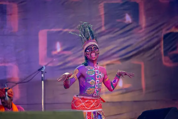 stock image Pushkar, Rajasthan, India - November 06 2022: Indian male artist performing rajasthani folk dance Sahariya tribe with painted face and colorful paint on body with ethnic dress at fair.