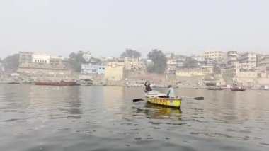 Varanasi, Uttar Pradesh, Hindistan - 20 Ocak 2024: Turistler ve yerliler sabah erken saatlerde Ganj Nehri 'nde tekne gezisinin keyfini çıkarıyorlar.  