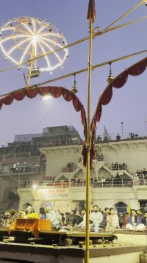 Varanasi, Uttar Pradesh, Hindistan - 20 Ocak 2024: Ganga aarti, Hindu ayinleriyle geleneksel elbise içinde Assi Ghat 'ta sabahın erken saatlerinde Ganj Nehri' nin kutsal nehrinde gösteri yapan Hintliler..