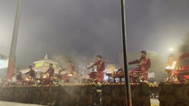 Varanasi, Uttar Pradesh, Hindistan - 20 Ocak 2024: Ganga aarti, Hindu ayinleriyle geleneksel elbise içinde Assi Ghat 'ta sabahın erken saatlerinde Ganj Nehri' nin kutsal nehrinde gösteri yapan Hintliler..