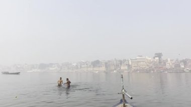 Varanasi, Uttar Pradesh, Hindistan - 05 Mart 2023: Eğlence için Ganj Nehri 'nde yüzen gençlerin görüntüleri.