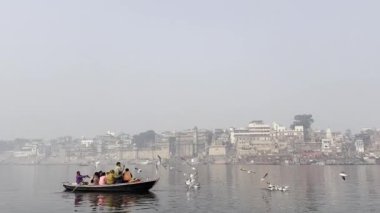Varanasi, Uttar Pradesh, Hindistan - 20 Ocak 2024: Turistler ve yerliler sabah erken saatlerde Ganj Nehri 'nde tekne gezisinin keyfini çıkarıyorlar.  