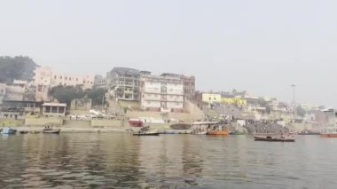 Varanasi, Uttar Pradesh, Hindistan - 20 Ocak 2024: Turistler ve yerliler sabah erken saatlerde Ganj Nehri 'nde tekne gezisinin keyfini çıkarıyorlar.  
