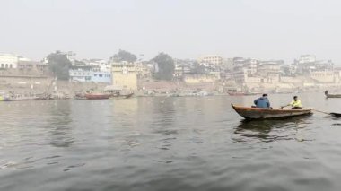 Varanasi, Uttar Pradesh, Hindistan - 20 Ocak 2024: Turistler ve yerliler sabah erken saatlerde Ganj Nehri 'nde tekne gezisinin keyfini çıkarıyorlar.  