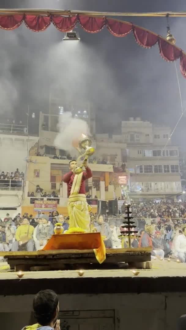ヴァラナシ ウッタルプラデシュ インド 2024年1月19日 ガンガ アソー 聖なる川ギャングの夕方 ヒンドゥー教の儀式で伝統的なドレスでダッシュウォッシュメイドガットで踊る若い司祭の映像 — ストック動画