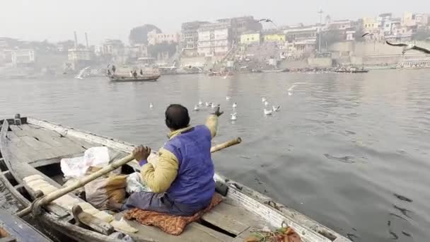 ヴァラナシ ウッタルプラデシュ インド 2024年1月20日 早朝にヴァラナシュのガンジス川でボートに乗る観光客や地元の人々 聖なる川ガンジスで木製のボートを航海するボートマン — ストック動画