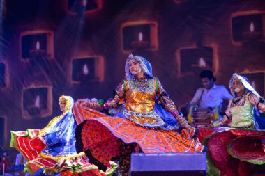 Puşkar, Rajasthan, Hindistan - Kasım 06 2022: Ramazan halk dansını renkli etnik rajasthani elbisesi ve mücevherleriyle sahnede yapan sanatçı.