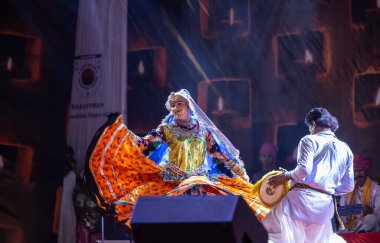 Puşkar, Rajasthan, Hindistan - Kasım 06 2022: Ramazan halk dansını renkli etnik rajasthani elbisesi ve mücevherleriyle sahnede yapan sanatçı.