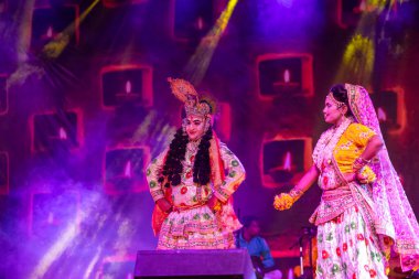 Puşkar, Rajasthan, Hindistan - Kasım 06 2022: Sanatçılar renkli etnik giysiler içinde itici kar fuarı sırasında Lord Krishna olarak çiçek vadisi sergiliyorlar.