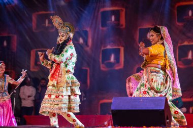Puşkar, Rajasthan, Hindistan - Kasım 06 2022: Sanatçılar renkli etnik giysiler içinde itici kar fuarı sırasında Lord Krishna olarak çiçek vadisi sergiliyorlar.