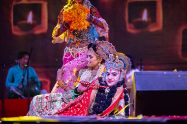 Puşkar, Rajasthan, Hindistan - Kasım 06 2022: Sanatçılar renkli etnik giysiler içinde itici kar fuarı sırasında Lord Krishna olarak çiçek vadisi sergiliyorlar.