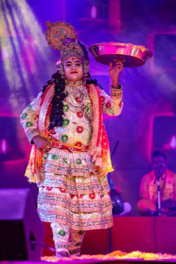 Puşkar, Rajasthan, Hindistan - Kasım 06 2022: Erkek sanatçı renkli etnik giysiler içinde itici kar fuarı sırasında Lord Krishna olarak çiçek vadisi açtı.