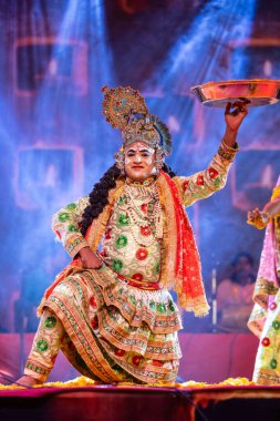 Puşkar, Rajasthan, Hindistan - Kasım 06 2022: Erkek sanatçı renkli etnik giysiler içinde itici kar fuarı sırasında Lord Krishna olarak çiçek vadisi açtı.