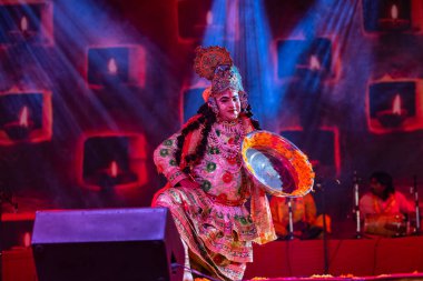 Puşkar, Rajasthan, Hindistan - Kasım 06 2022: Erkek sanatçı renkli etnik giysiler içinde itici kar fuarı sırasında Lord Krishna olarak çiçek vadisi açtı.