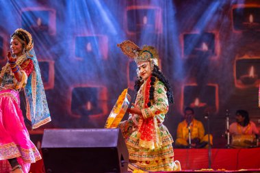 Puşkar, Rajasthan, Hindistan - Kasım 06 2022: Sanatçılar renkli etnik giysiler içinde itici kar fuarı sırasında Lord Krishna olarak çiçek vadisi sergiliyorlar.