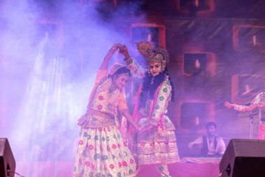 Puşkar, Rajasthan, Hindistan - Kasım 06 2022: Sanatçılar renkli etnik giysiler içinde itici kar fuarı sırasında Lord Krishna olarak çiçek vadisi sergiliyorlar.