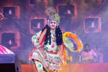 Puşkar, Rajasthan, Hindistan - Kasım 06 2022: Erkek sanatçı renkli etnik giysiler içinde itici kar fuarı sırasında Lord Krishna olarak çiçek vadisi açtı.