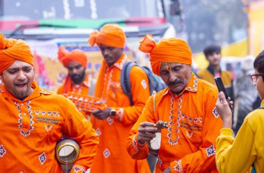 Gaziabad, Uttar Pradesh, Hindistan - 28 Ocak 2024: Yılan oynatıcı topluluğunun erkek folk sanatçıları, iskon rath yatra sırasında geleneksel kıyafetleriyle müzik aleti kullanıyorlar.