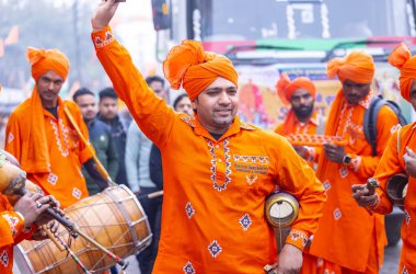 Gaziabad, Uttar Pradesh, Hindistan - 28 Ocak 2024: Yılan oynatıcı topluluğunun erkek folk sanatçıları, iskon rath yatra sırasında geleneksel kıyafetleriyle müzik aleti kullanıyorlar.