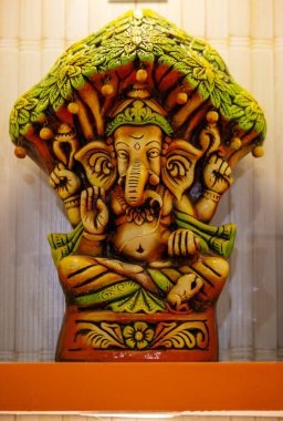 Wooden art, handmade colorful Lord Ganesh souvenir made with wood in display to worship. clipart